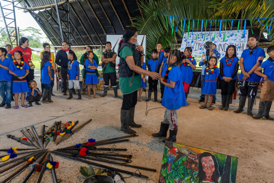 La abuela Graciela Quenamá entrega a los niños y las niñas del Semillero de Guardia sus lanzas, que simbolizan su autoridad sobre el territorio, su compromiso de defenderlo y su posesión como Chipiri Tsampi Kuirasunde’khu. Foto: cortesía Morelia Mendúa / Alianza Ceibo.